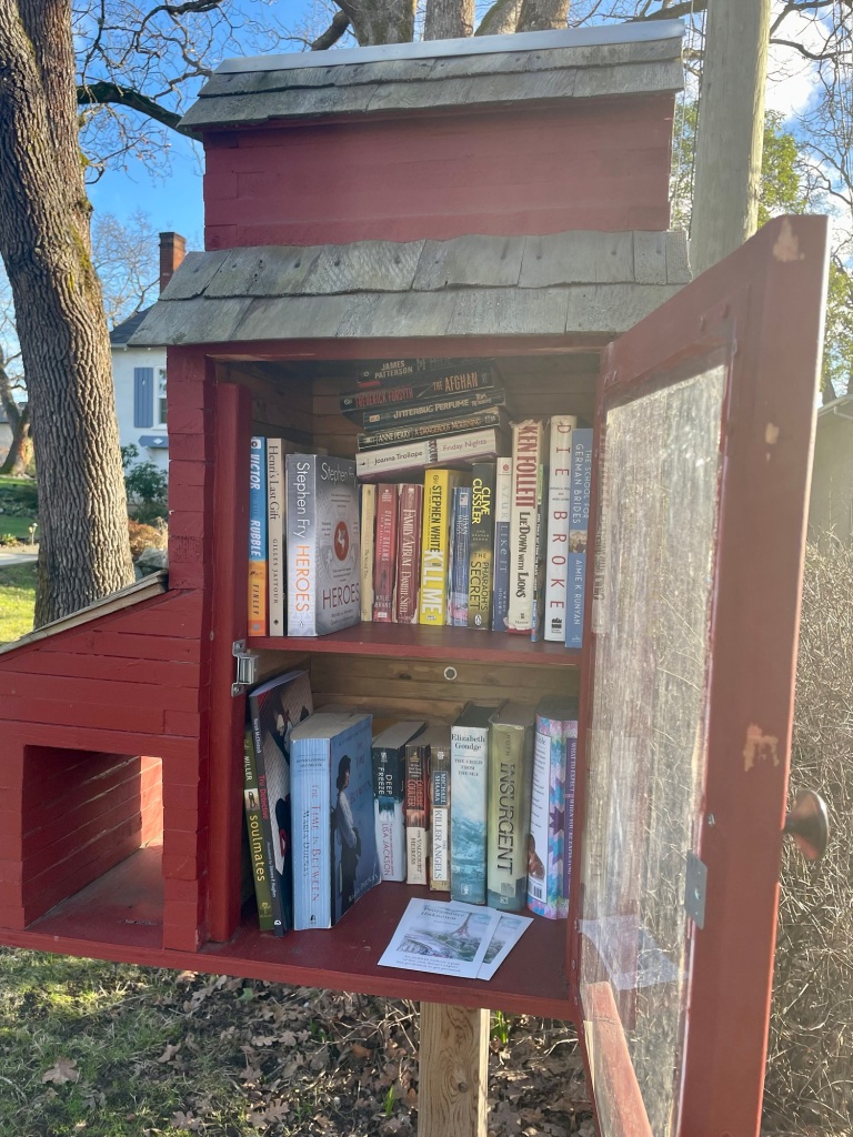 Little free library shaped like a red barn.